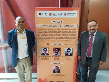 Prof. Sijariya beside a poster for Panel 3 on entrepreneurship, innovation and startups